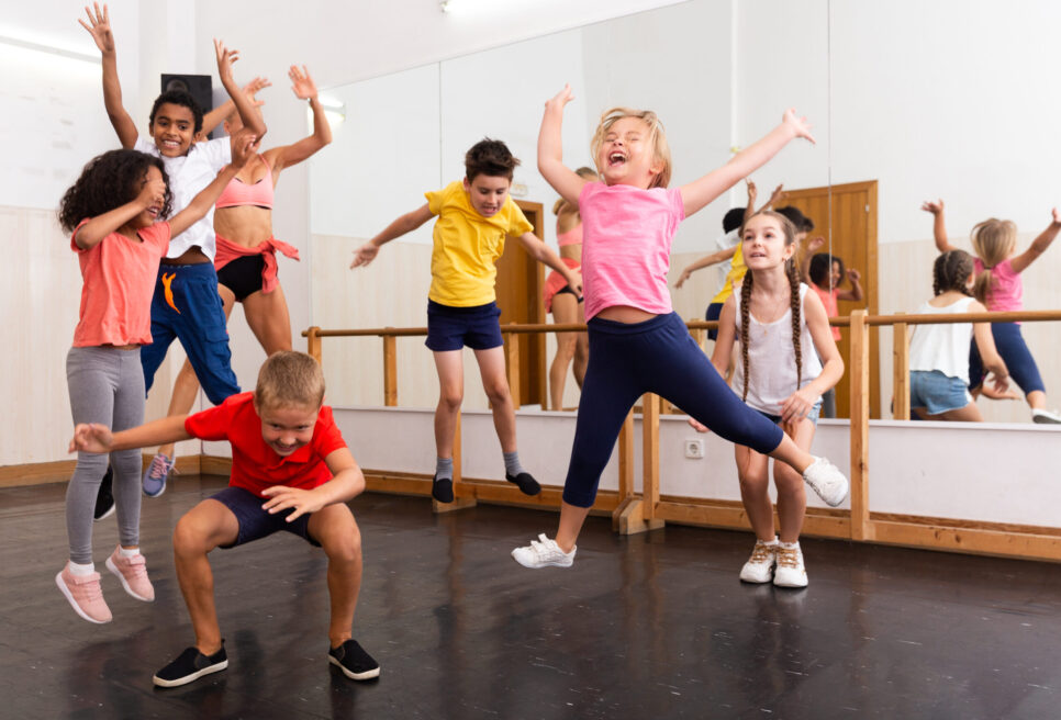 Group,Of,Happy,Sporty,Kids,With,Female,Teacher,Training,In